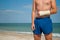 Gypsum fracture on a man`s hand, sand close-up against the background of the sea and the sky clouds, broken arm limb