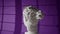 gypsum head of man or woman rotates, light from window falls on velvet violet background. Hard dramatic light on plaster