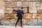 Gypsy man dancing flamenco, young and handsome dressed in black and red shoes is posing and dancing on a background of a stone