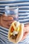 Gyros and a glass of water in the hands of a man on striped back