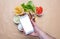 Gyros and smartphone. Hand holding a mobile phone with blank white screen, gyro pita ingredients background