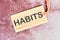 HABITS word written on a card with a rope on an abstract background