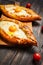 Hachapuri Adjara. Beautiful open pies khachapuri with egg on wooden