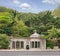 Haci Mehmet Emin Aga Fountain, or Sebil, near Dolmabahce, against hill with dense green trees, Istanbul, Turkey