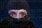 Hacker with balaclava over a screen with binary code