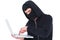 Hacker in balaclava typing on laptop