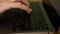 Hacker hands typing code on laptop keyboard, light of police emergency lights.