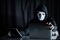 Hacker man holding white mask looking at laptop