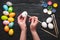 Hads painting eggs for Easter holiday on wooden table