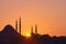 Hagia Sophia, the most important tourist attraction of Istanbul, Turkey, silhouetted against the ochre sunset sky.