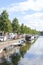 The Hague, The Netherlands - May 15 2020: Canal with reflection of boats and trees, street filled with cars and houses