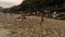 Hainan, China - January 13, 2020 : Family plays with a ball in the sand on a sea beach at sunset.