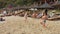 Hainan, China - January 13, 2020 : Family plays with a ball in the sand on a sea beach at sunset.