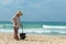 Hainan Island, Sanya, China - May 16, 2019: A cleaning lady picks up trash on Hainan Beach with special handy forceps