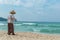 Hainan Island, Sanya, China - May 16, 2019: A cleaning lady picks up trash on Hainan Beach with special handy forceps