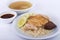 Hainanese chicken rice, steamed chicken, chicken blood and white rice on brown cloth background.