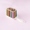 Hair brush made of wooden crayons of different colors. Minimal concept on a pink background