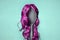 Hair coloring. Comb with pink wig on turquoise background, similar to woman's head. Concept of hair care, baldness