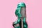 Hair coloring and dye. Comb with turquoise wig on pink background, like woman's head. Hairstyle and beauty salon