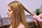 hair diagnostics to young female client by unrecognizable professional cosmetologist