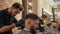 Hair dresser using electric shaver for hair cutting bearded man in barber shop. Hairstylist using trimmer for brutal