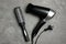 Hair dryer and brush on marble table, flat lay. Professional hairdresser tool