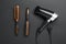 Hair dryer and brushes on background, flat lay. Professional hairdresser tool