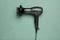 Hair dryer on green background. Professional hairdresser tool