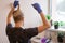 Hair dyeing at home. Young man in blue gloves coloring his hairs by himself