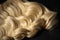 Hair extensions isolated on black background. Top view. Curly wavy hair. Blonde wavy hairstyles. Temporary hairstyle for special