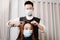 Hair salon concept both male hairstylist and female customer wearing a protective face masks during haircut process