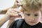 Hair salon that specializes in toddlers. Little boy with blond hair at hairdresser. Small child in hairdressing salon