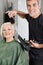 Hair Stylist Blow Drying Senior Woman\'s Hair