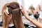 Hair stylist creates volume and styling for brown hair on a woman`s head