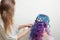 Hair stylist doing styling on long curls. Bright multi-colored hair coloring