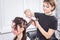 Hair stylist making new haircut to brunette woman in salon