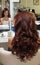 Hair stylist making ringlets to brunette woman. Hairdresser work