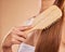 Hairbrush, hair care and woman brushing her hair in a studio for wellness, health and self care. Cosmetic, beauty and