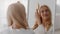 Haircare Concept. Smiling Woman Combing Her Beautiful Bleached Blonde Hair Near Mirror