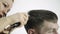 Haircut at barbershop. hairdresser uses scissors for cutting a man. Female hairdresser shaping mens hair cutting uses