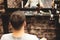 Haircut head in barbershop. Barber cuts hair on head of the client. The process of creating hairstyles for men. Selective focus.