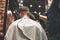 Haircut head in barbershop. Barber cuts hair on head of the client. The process of creating hairstyles for men. Selective focus.