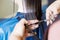 Haircuting in a beauty professional salon. hairdresser`s hands cutting brunette hair close