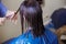 Haircuting in a beauty professional salon. hairdresser`s hands cutting brunette hair close