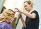 Hairdo in beauty salon. hairdresser fixing hair with hairspray