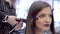 Hairdresser applying hair curlers to hairstyle young beautiful girl close-up