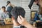 Hairdresser blow drying his client hair after finished haircut. Asian young man being blow dry hair with hairdryer