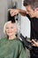 Hairdresser Blow Drying Woman\'s Hair