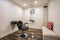 Hairdresser chair and backwash shampoo bowl inside salon with bench and mirror