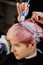 Hairdresser colorist dyes the hair of a woman to a client in different colors.
